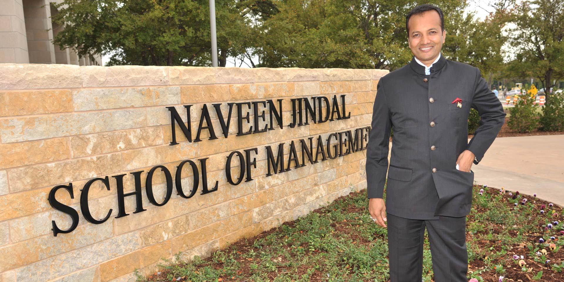 Naveen Jindal with the sign of the business school that bears his name at UT Dallas